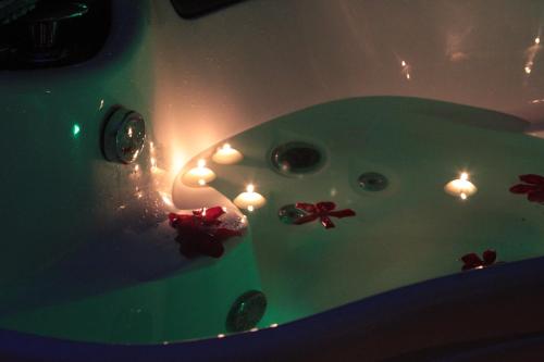 a group of lit candles in a bath tub at Kuredu / Uroa w Krainie Alicji in Ełk