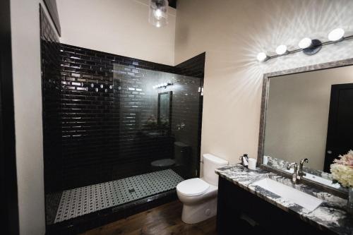 a bathroom with a shower and a toilet and a sink at GunRunner Boutique Hotel in Florence