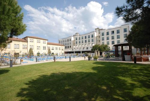 a park in a city with buildings and a grass field at Hotel Dante Family Spa Resort in Cervia