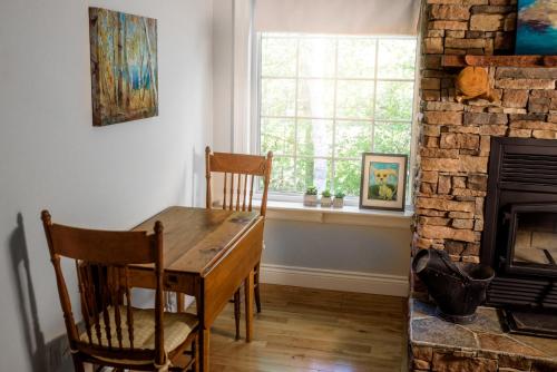 a dining room with a table and chairs and a fireplace at The Kitch'inn - Boutique Inn and Wine Bar in Mahone Bay