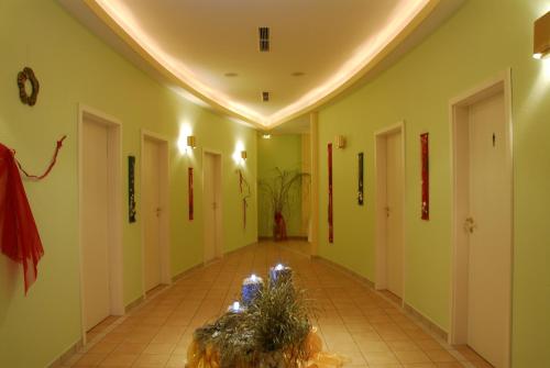 a hallway with a plant in the middle of a room at Kurhotel Fürstenhof by David in Blankenburg