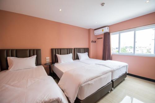 a hotel room with two beds and a window at Let's Zzz Bangkok in Bangkok