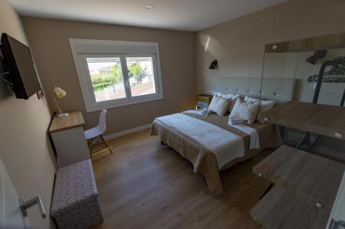 un dormitorio con una cama y una ventana en A Xanela Indiscreta, en Redondela