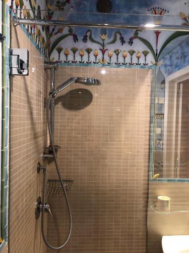 a shower with a glass door in a bathroom at “Il Mosaico” Suite Apartment - Grottaglie in Grottaglie