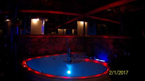 a bathroom with a bath tub with red and blue lights at Kuredu / Uroa w Krainie Alicji in Ełk