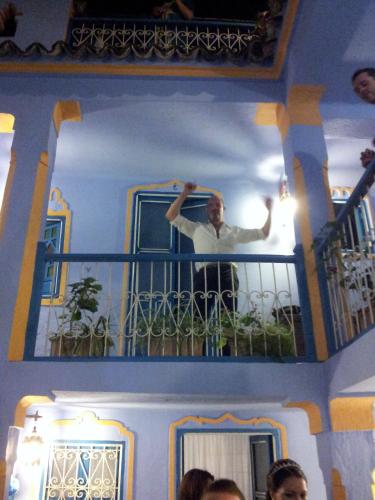 a man standing on a balcony of a house at Hôtel Dar Terrae in Chefchaouene