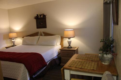 a bedroom with a bed and a table with two lamps at Village Lodge in Ruidoso