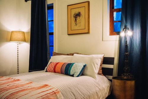 um quarto com uma cama com uma almofada em Renovated Historic Coconut Grove Cottage Home em Miami