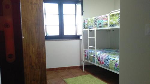 a room with two bunk beds and a window at A Minguxaina in Ribadeo
