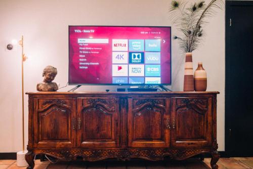 a television on top of a wooden entertainment center at Renovated Historic Coconut Grove Cottage Home in Miami