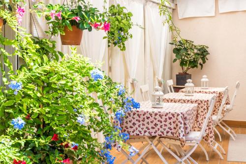 2 mesas y sillas en un jardín con flores en B&B La Bragadina, en Lido de Venecia