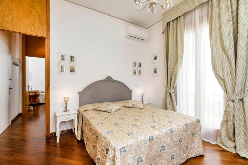 a white bedroom with a bed and a window at B&B La Bragadina in Venice-Lido