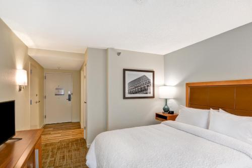 a hotel room with a bed and a flat screen tv at Hampton Inn Columbia-I-26 Airport in Columbia