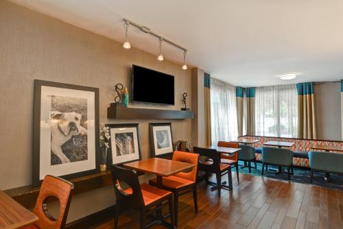 a dining room with tables and chairs and a flat screen tv at Hampton Inn Columbia-I-26 Airport in Columbia