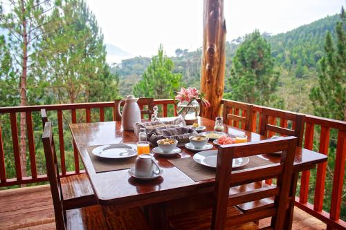 a wooden table with plates of food on a balcony at Altares de Oxapampa in Oxapampa