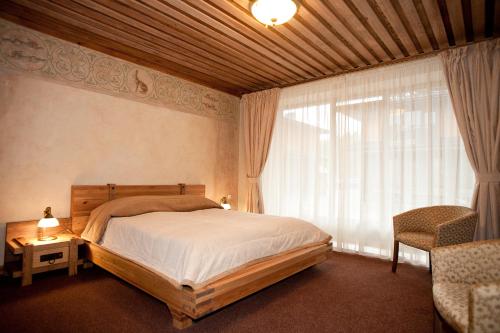a bedroom with a bed and a large window at Vila Dubgiris in Plinkšės