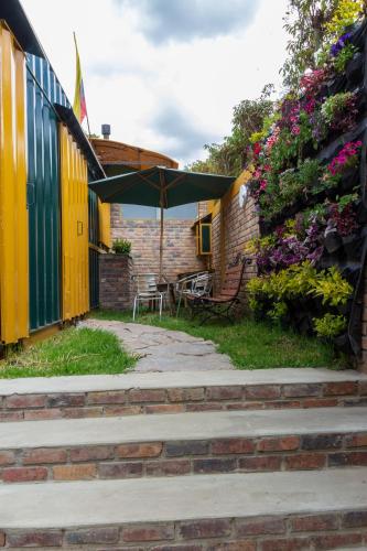 a patio with a table and an umbrella at Los Vagones de William in Tibasosa
