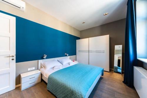 a blue bedroom with a bed and a blue wall at All You Need in Zagreb