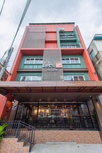 a building with a restaurant in front of it at Let's Zzz Bangkok in Bangkok