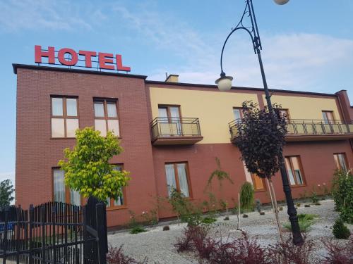 a hotel building with a sign on top of it at Zajazd u Piasta Kołodzieja in Kruszwica