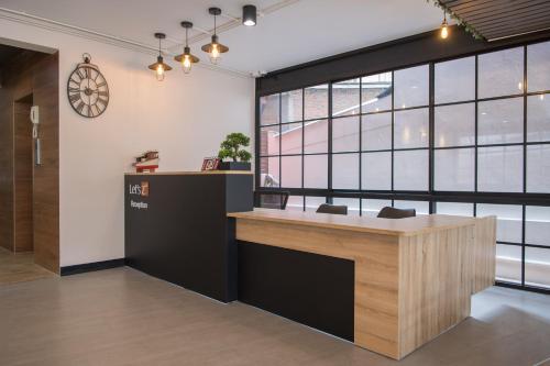 an office with a reception desk and a clock on the wall at Let's Zzz Bangkok in Bangkok