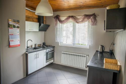 a small kitchen with a sink and a window at Andiamo in Korbielów