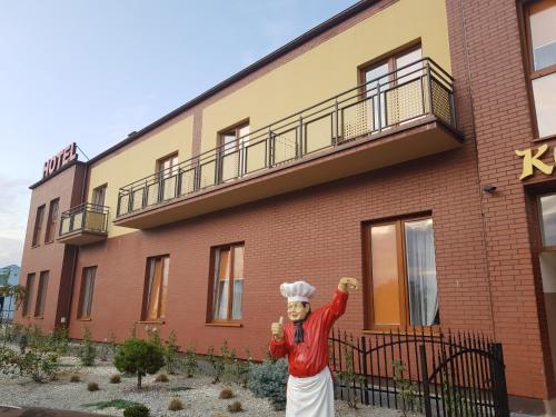 a statue of a chef standing in front of a building at Zajazd u Piasta Kołodzieja in Kruszwica