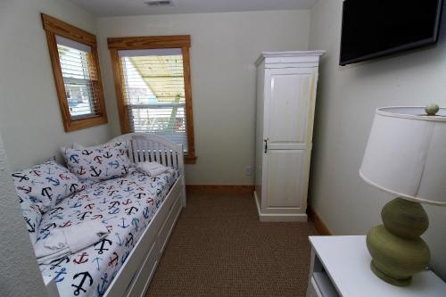 a small bedroom with a bed and a window at Whalebone Ocean Cottages by KEES Vacations in Nags Head