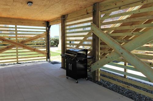 a room with a wooden fence and a grill at Whalebone Ocean Cottages by KEES Vacations in Nags Head
