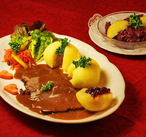 a plate of food with meat and potatoes on a table at Hotel Goldener Fasan in Oranienbaum-Wörlitz