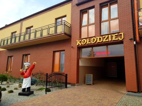 a statue of a person standing in front of a building at Zajazd u Piasta Kołodzieja in Kruszwica