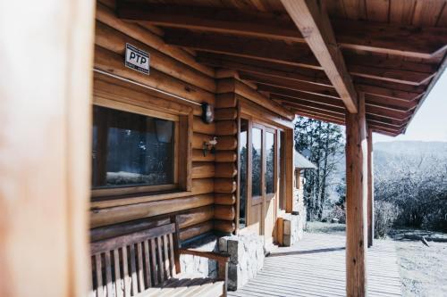 una cabaña de madera con un cartel en la parte delantera en Arrayan Lake View Mountain Lodge & Casa De Te Arrayan en San Martín de los Andes