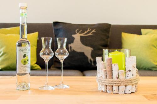 a bottle of wine and two wine glasses on a table at Ferienhaus Obwallhof in Fieberbrunn