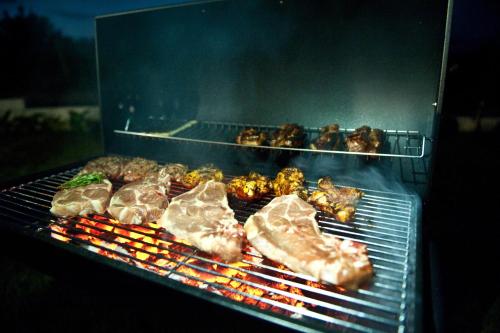 a bunch of food is cooking on a grill at Nature Home Apartment in Sandra