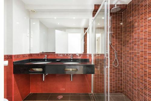 a bathroom with two sinks and a mirror at Victory Village 9F in Quinta do Lago