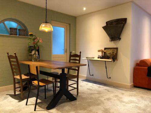 a dining room with a wooden table and chairs at The Old Garage in Tilburg