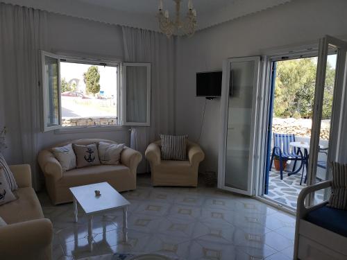 un soggiorno con divano, sedie e patio di Minas House Antiparos a Città di Antiparo