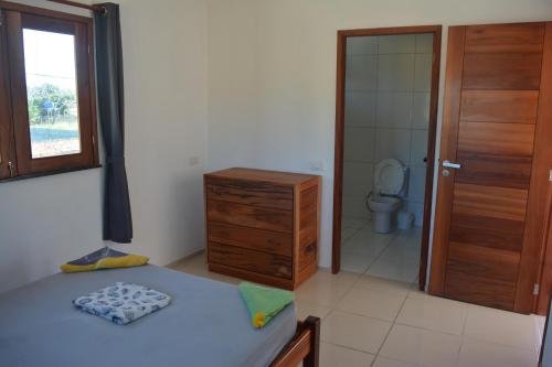 a bathroom with a bed and a sink and a toilet at Casa do Sol in Paracuru