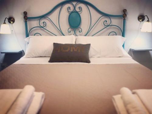 a bed with a blue headboard with a pillow on it at Il Sole di Mondello in Mondello