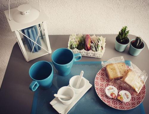 a table with a plate of food and two cups at Il Sole di Mondello in Mondello