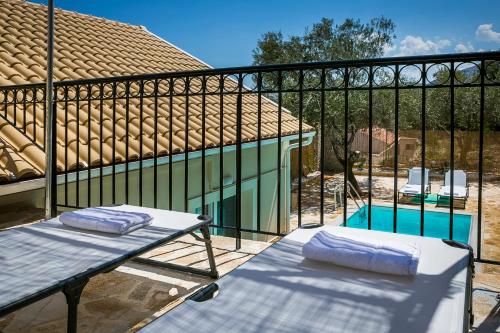 a balcony with a table and chairs next to a swimming pool at Villa Pilali in Kefallonia