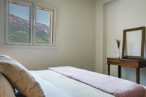 a bedroom with a bed with a mirror and a table at Villa Pilali in Kefallonia