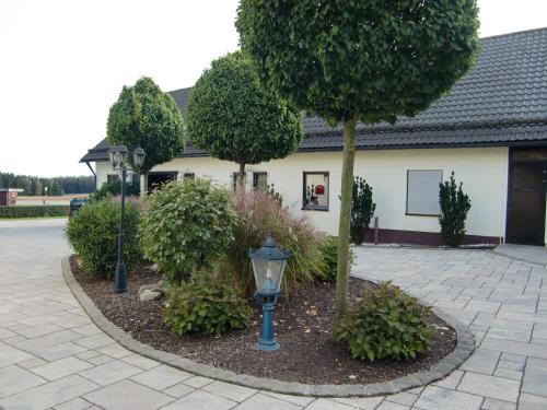 a garden with a street light and trees and a building at Landhotel Fuchsbau in Vohenstrauß