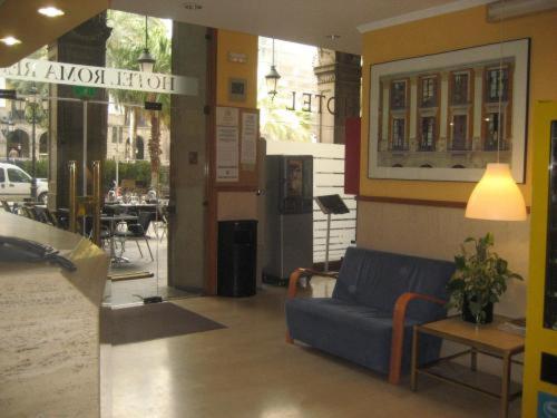 a lobby with a blue couch and a table at Roma Reial in Barcelona