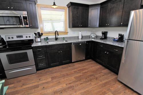 a kitchen with black cabinets and stainless steel appliances at Whalebone Ocean Cottages by KEES Vacations in Nags Head