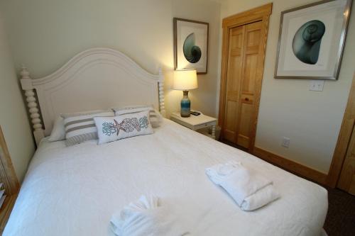 a bedroom with a white bed with towels on it at Whalebone Ocean Cottages by KEES Vacations in Nags Head