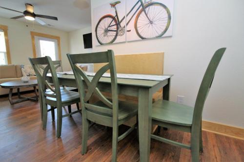 a dining room table and chairs with a bike on the wall at Whalebone Ocean Cottages by KEES Vacations in Nags Head
