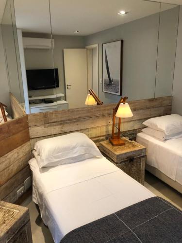 Habitación de hotel con 2 camas y TV en Flat Prudente de Morais, en Río de Janeiro