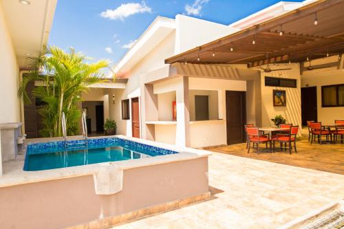 a villa with a swimming pool in front of a house at Hotel El Viejo Inn in Chinandega