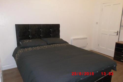 ペイズリーにある223 Neilston Roadのベッドルーム1室(黒いヘッドボード付きのベッド1台付)